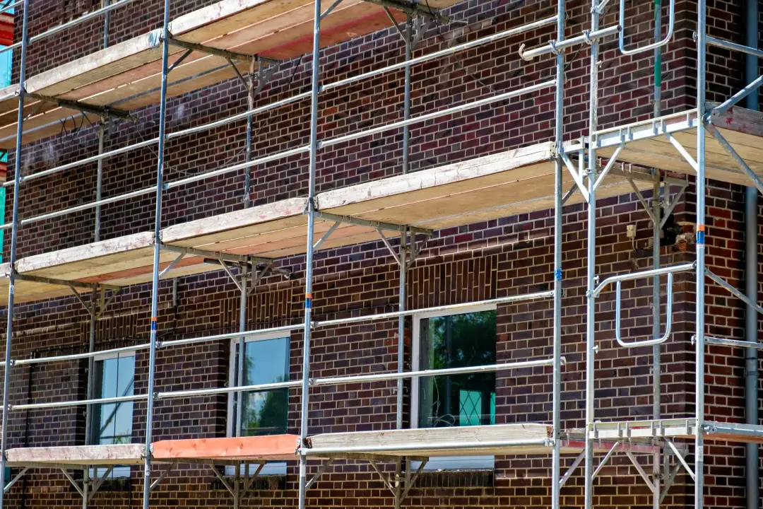 Scaffolders working on a brick building